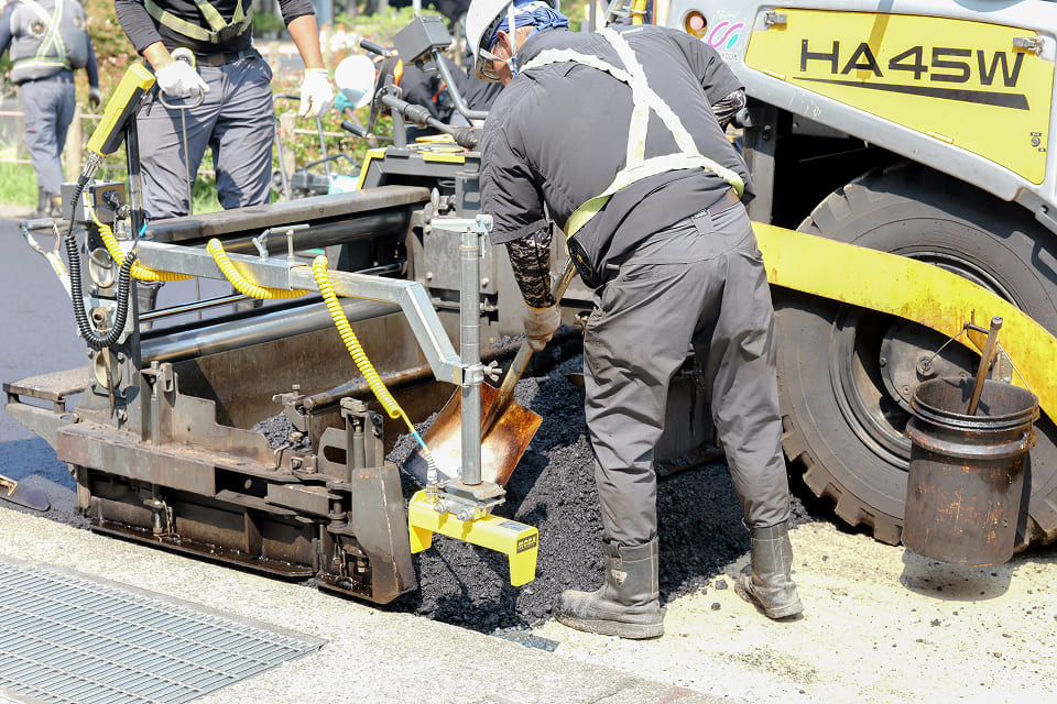 コンクリを流し込む補助をするスタッフ